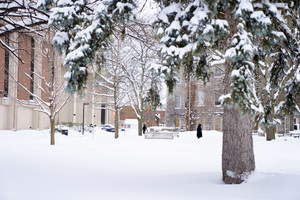 Students walk through Syracuse University's quad on a snowy day.
