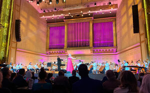 Leah Steinman, soloist in the Boston Pops orchestra, sings to an audience in the Symphony Hall. Despite a vocal nodules diagnosis, Steinman performs accompanied by a live band.