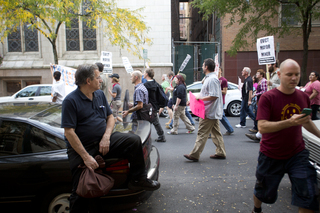 A man sat on his car and watched the Occupy march go by.