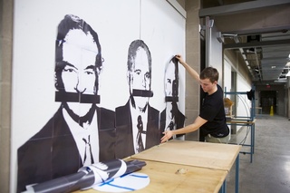 Miller hangs his portrait of Glenn Beck, the last of his three conservative figures.