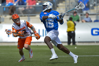 Duke midfielder Myles Jones looks to make a move as Syracuse long-stick midfielder Peter Macartney closes in.