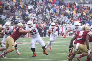 Dungey surveys the fieldwhile Aaron Roberts (59) blocks in front of him.